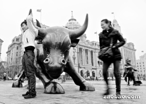 世界银行认为中国可在2030年超越美国,成为全球最大规模经济体。图为游客与上海金融区的“外滩牛”塑像拍照。(彭博社)